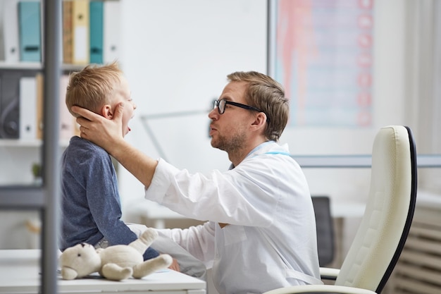 Männlicher Arzt, der die Gesundheit des Kindes untersucht