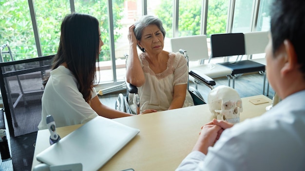 Foto männlicher arzt, der eine kraniofaziale deformität bei einer älteren patientin im untersuchungsraum diagnostiziert