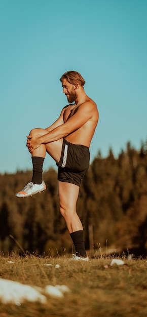 Männlicher Athlet, der Armstreckübungen auf einem Berg macht.