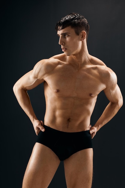 Männlicher Athlet, dunkler Feigling, muskulöser Körper, Studio, dunkler Hintergrund, hochwertiges Foto