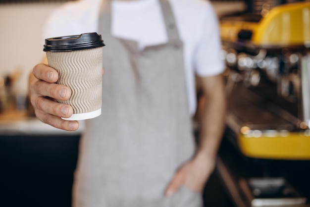 Männlicher Barista serviert Kaffee in Pappbechern