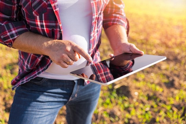 Männlicher Bauer, der moderne Technologie für Smart Farming verwendet