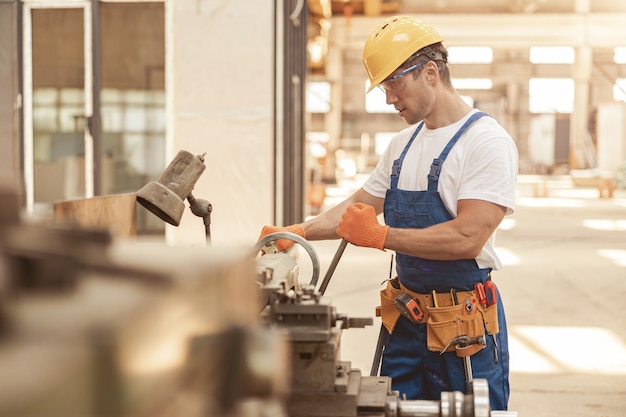 Männlicher Baumeister mit professioneller Ausrüstung in der Werkstatt