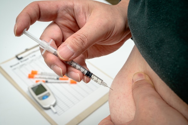 Männlicher Diabetiker, der sich mit Insulin injiziert