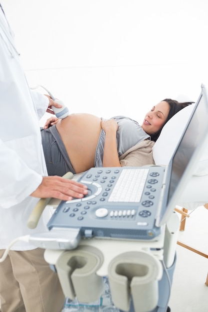 Männlicher Doktor, der schwangere Frau überprüft