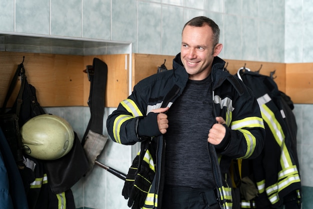 Männlicher Feuerwehrmann verkleidet sich für die Arbeit