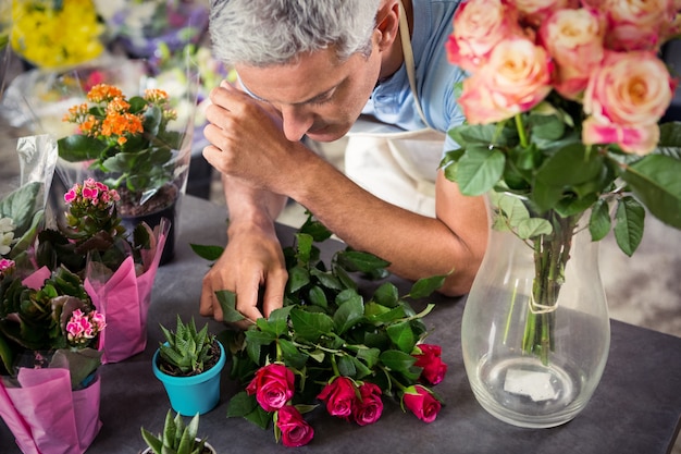 Männlicher Florist, der Blumen arrangiert