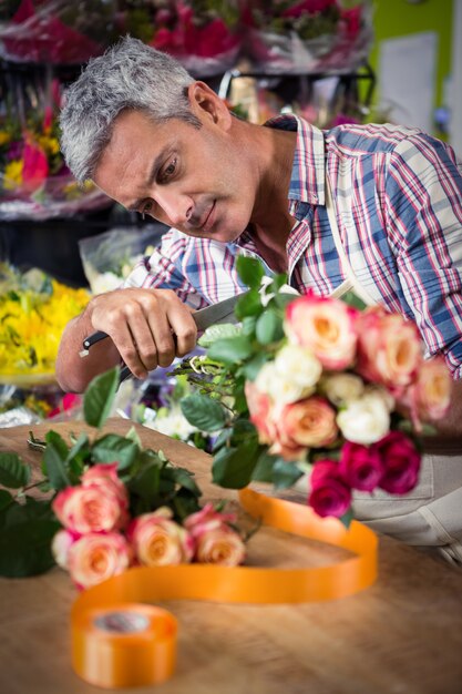 Männlicher Florist, der Blumenstrauß vorbereitet