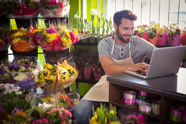 Männlicher Florist mit Laptop