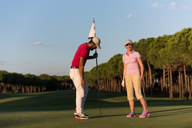 männlicher golflehrer, der weibliche golfspieler unterrichtet, persönlicher trainer, der unterricht auf dem golfplatz gibt