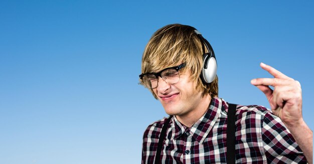 Männlicher Hipster, der beim Musikhören mit den Fingern schnippt