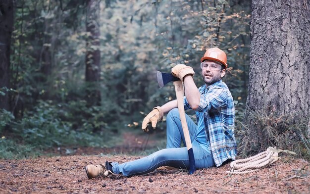 Männlicher Holzfäller im Wald. Ein professioneller Holzfäller untersucht Bäume zum Fällen.