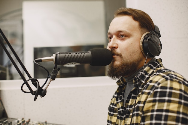 Männlicher Host, der am Mikrofon kommuniziert. Mann im Radiostudio.