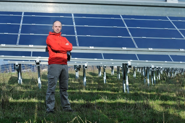 Männlicher Ingenieur am Arbeitsplatz, Solarpanel-Anlagenindustrie im Hintergrund