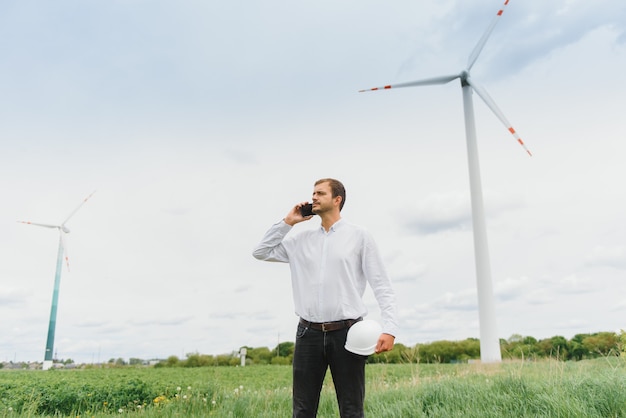 Männlicher Ingenieur am Telefon am Windkraftpark