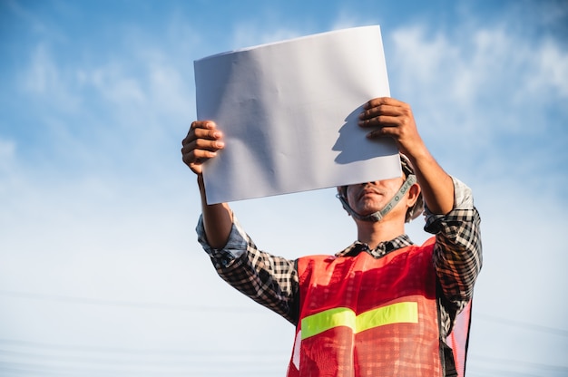 männlicher Ingenieur, der auf der Baustelle im Freien arbeitet