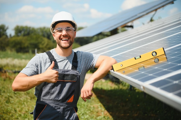 Männlicher Ingenieur im Schutzhelm, der Solar-Photovoltaik-Panel-System installiert. Ökologisches Konzept der alternativen Energie.