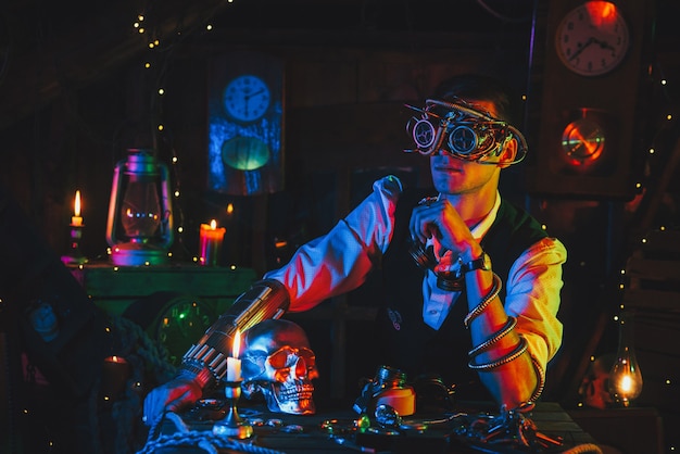 Männlicher Ingenieur in Cyberpunk-Brille und Steampunk-Anzug in einer Werkstatt mit Neonlicht