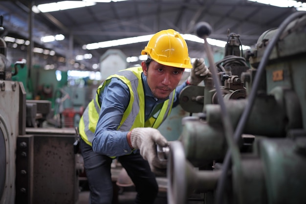 Männlicher Ingenieur Metallarbeiter industriell erfahrener Bediener Techniker Arbeiter mit Schutzhelm, der an Drehmaschinen arbeitet, professioneller Mann in der Fabrikwerkstatt für Industrietechnologie