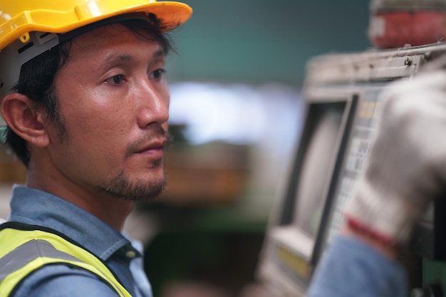 Männlicher Ingenieur Metallarbeiter industriell erfahrener Bediener Techniker Arbeiter mit Schutzhelm, der an Drehmaschinen arbeitet, professioneller Mann in der Fabrikwerkstatt für Industrietechnologie