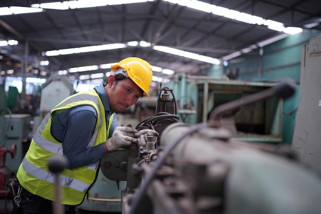 Männlicher Ingenieur Metallarbeiter industriell erfahrener Bediener Techniker Arbeiter mit Schutzhelm, der an Drehmaschinen arbeitet, professioneller Mann in der Fabrikwerkstatt für Industrietechnologie