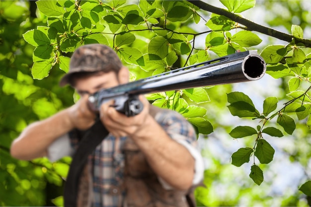 Männlicher Jäger mit Gewehr im Wald