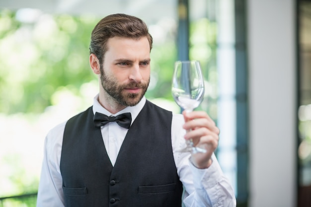 Männlicher Kellner, der Weinglas im Restaurant hält