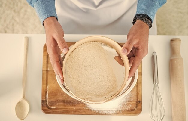 Männlicher Koch bereitet Essen in der heimischen Küche zu und macht Teig