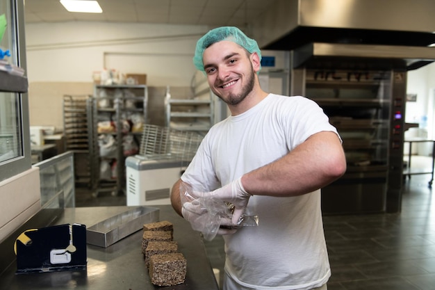 Männlicher Koch verpackt frisch gebackenes Brot in Kisten