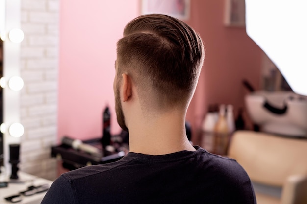 Männlicher Kopf mit stilvollem Haarschnitt auf Barbershop-Hintergrund