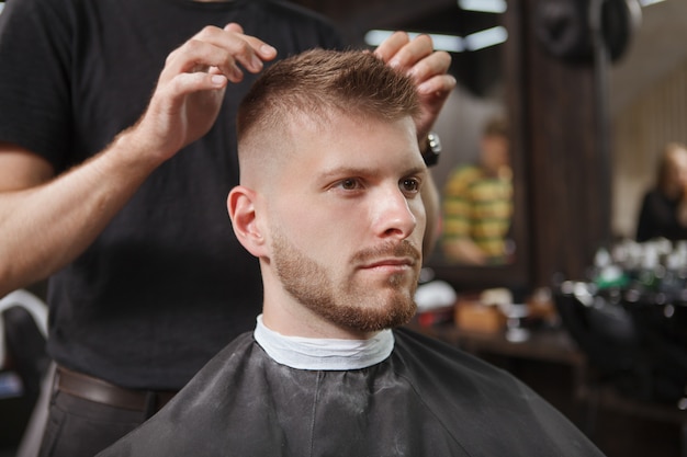 Männlicher Kunde, der Haarschnitt am Friseursalon erhält