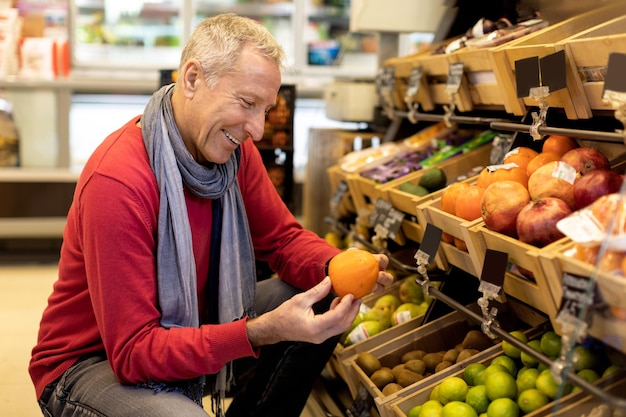 Männlicher Kunde, der hochwertige Produkte im Supermarkt genießt