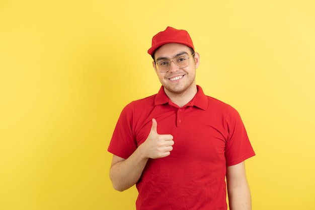 männlicher Kurier in roter Uniform stehend und Daumen hoch.