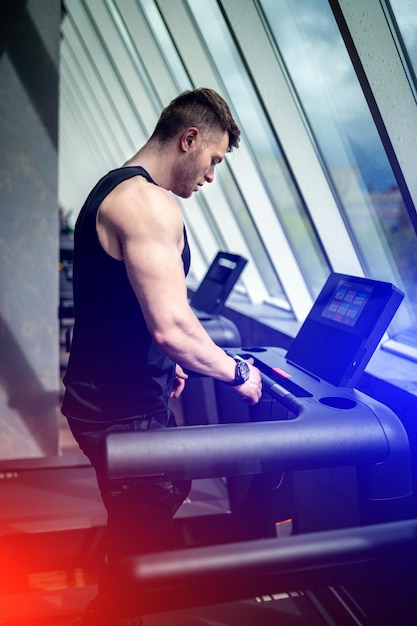 Männlicher Läufer auf Laufband im Fitnessstudio beim Cardio-Training Sportlicher starker Mann trainiert Cardio im Fitnessstudio