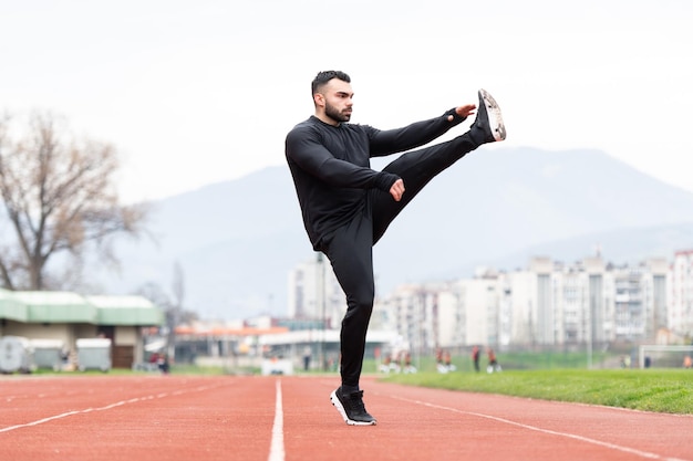 Männlicher Läufer, der sich vor dem Training streckt