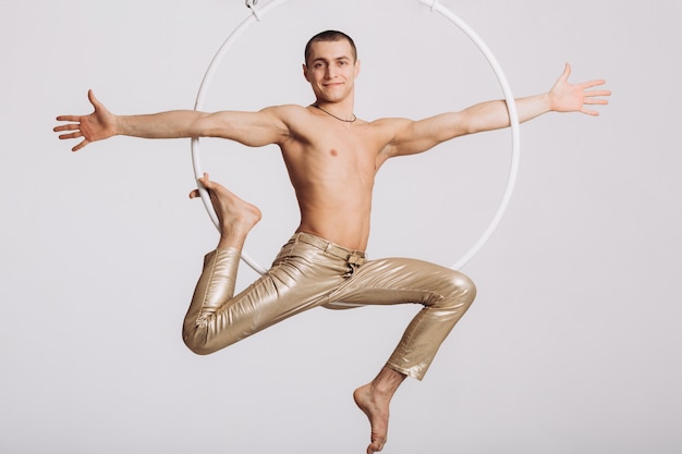 Männlicher Luftturner führt akrobatisches Element im Ring durch