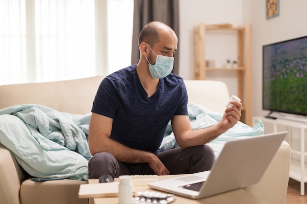 Männlicher Patient in Quarantäne rechtzeitig auf der Suche nach medizinischem Rat online.