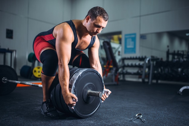 Männlicher Powerlifter bereitet eine Langhantel im Fitnessstudio vor