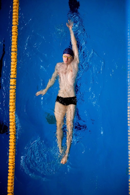 Männlicher professioneller Wettkampfschwimmer im Swimmingpool von oben