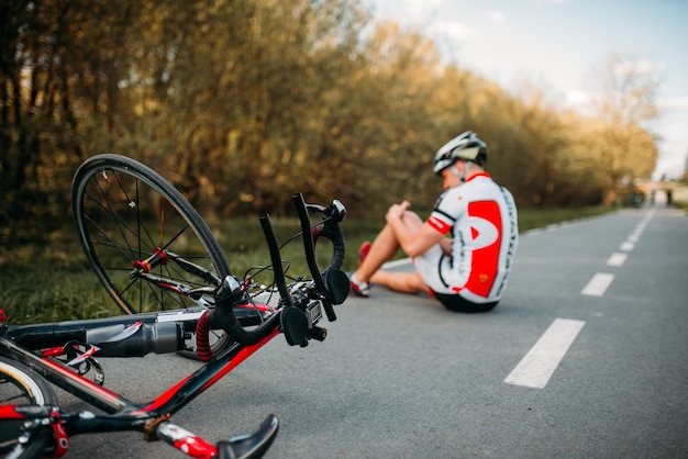 Männlicher Radfahrer fiel vom Fahrrad und schlug sich auf die Knie