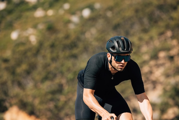 Männlicher Radfahrer in schwarzer Sportbekleidung beim Training