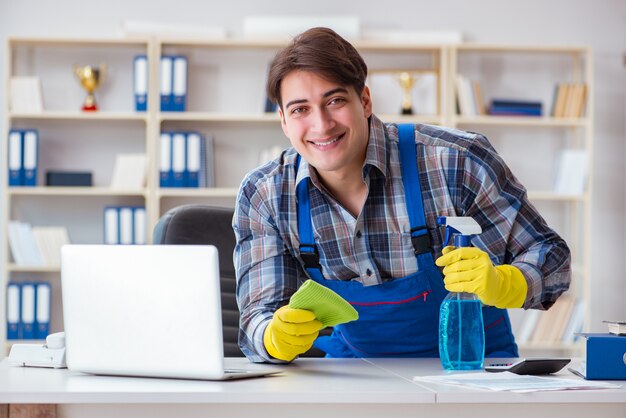 Männlicher Reiniger, der im Büro arbeitet