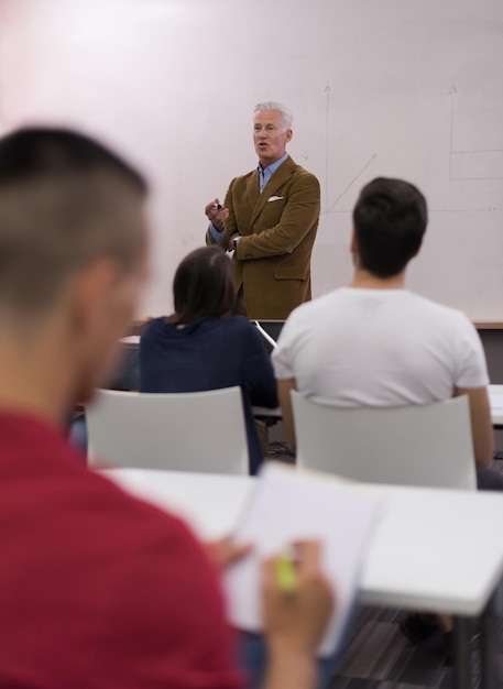 männlicher schüler, der sich im klassenzimmer notizen macht. betriebswirtschaftliches bildungskonzept, lässiger junger geschäftsmann im seminartraining