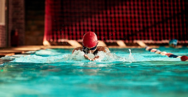 Männlicher Schwimmer trainiert im Pool. Direktaufnahme eines Schwimmers, der auf der Bahn im Pool Armschwünge macht