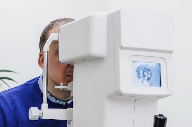 Foto männlicher sehtest auf dem gerät im optikgeschäft