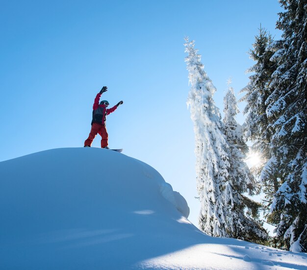 Männlicher Snowboarder-Freerider, der oben auf der Skipiste steht