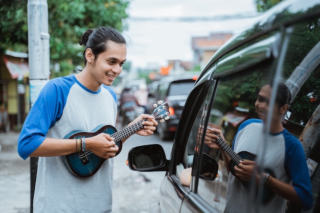 männlicher Straßenmusiker bettelt an der Ampel um Geld