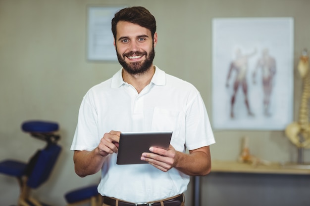 Männlicher Therapeut, der digitale Tablette in Klinik hält