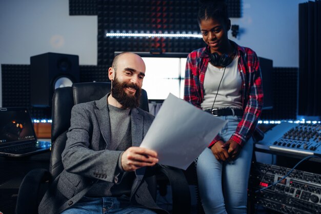 Männlicher Tonproduzent und Sängerin im Studio