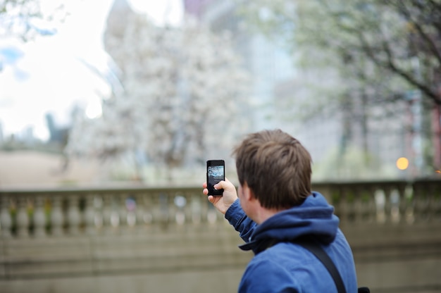 Männlicher Tourist des Mittelalters, der bewegliches Foto unter Verwendung seines intelligenten Telefons macht